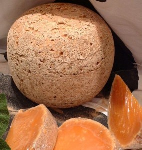 Mimolette is a hard, aged cheese that looks like a cantelope.  Somewhere between Cheddar and Gouda.